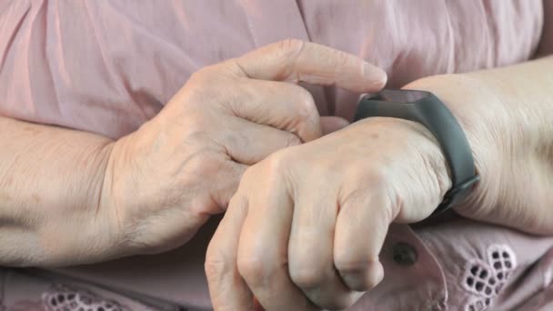 La anciana usando el rastreador de fitness de la pulsera — Vídeos de Stock