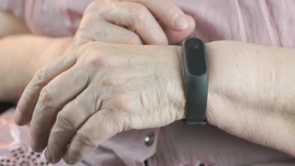 Yaşlı kadın bileklik fitness İzleyicisi'ni kullanma — Stok video