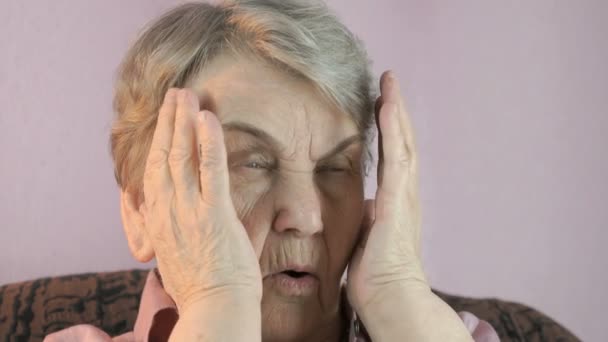 Взрослая женщина сидит в помещении закрывает лицо руки — стоковое видео