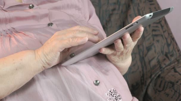 Seniorin hält silbernen Tablet-Computer in der Hand — Stockvideo