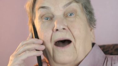 Yaşlı kadın cep telefonu üzerinde görüşmeler gülümseyerek. Yakın çekim