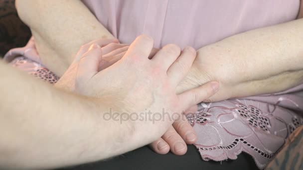 Hombre sosteniendo viejas manos arrugadas de mujer anciana — Vídeo de stock