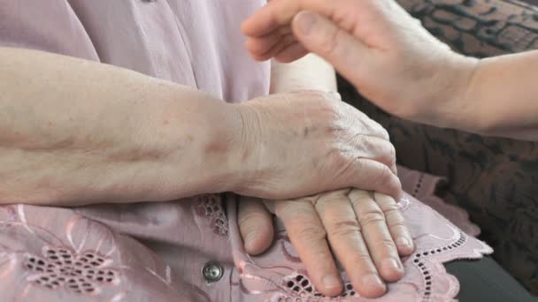 Mujer sosteniendo flácidas manos arrugadas de anciana — Vídeo de stock