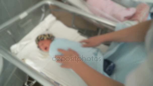 Nurse dresses up newly-born in hospital ward — Stock Video