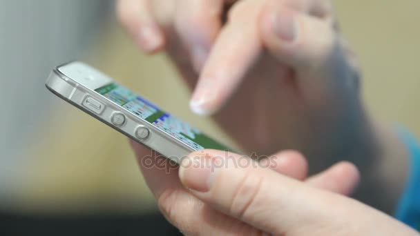 Mão das mulheres segurando o telefone celular prata — Vídeo de Stock
