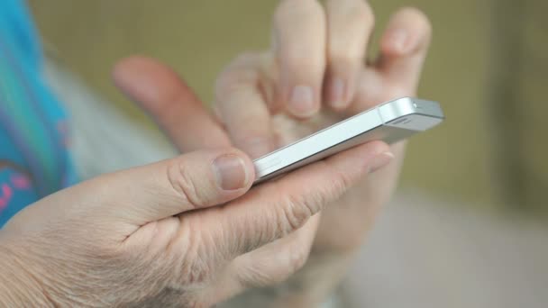 Mão das mulheres segurando o telefone celular prata — Vídeo de Stock