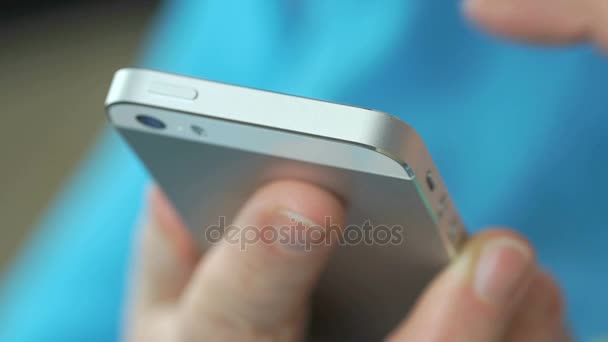 Donna inserisce testo sul telefono cellulare argento all'interno — Video Stock