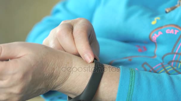 Kvinna klänningar fitness tracker på handleden. Närbild — Stockvideo