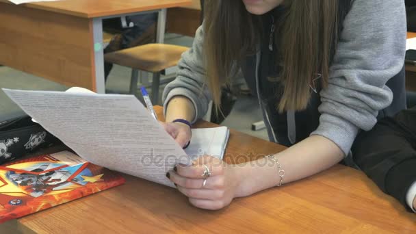 Estudante sentada em uma mesa da escola na lição — Vídeo de Stock