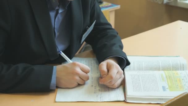 Leerling schrijft de tekst in het werkboek op Les — Stockvideo