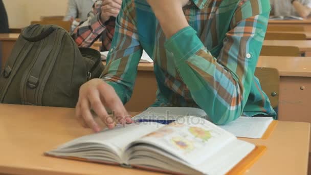 Ученик читает школьный учебник по уроку — стоковое видео