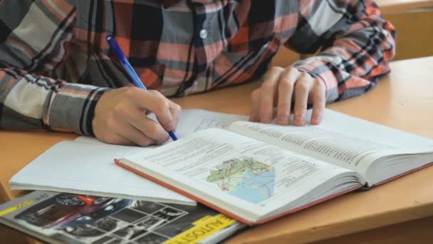 Leerling schrijft de tekst in het werkboek op Les — Stockvideo