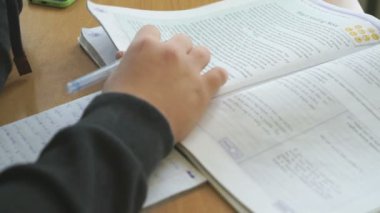 Okul masa başında oturan öğrenci ders kitabı okur