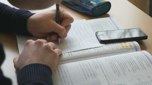 El alumno escribe el texto en una hoja blanca de papel — Vídeos de Stock