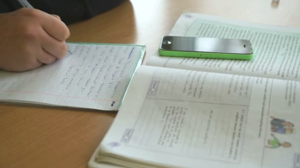 Schüler schreibt den Text in Notizbuch im Unterricht — Stockvideo