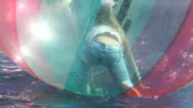 Küçük kızın büyük bir şişme top su içinde