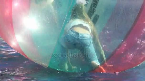 Κοριτσάκι μέσα σε μια μεγάλη φουσκωτή μπάλα στο νερό — Αρχείο Βίντεο
