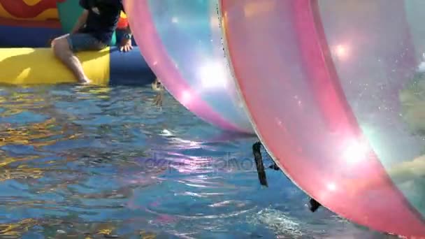 Kleines Mädchen stolpert in großen aufblasbaren Ball — Stockvideo