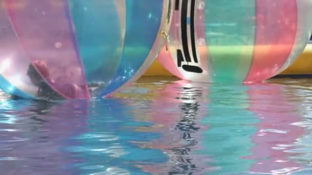 Kisfiú belsejében egy nagy felfújható labdát víz — Stock videók