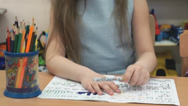 Маленькая девочка рисует картинки в блокноте — стоковое видео