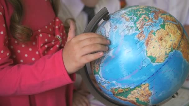 Menina pré-escolar gira o modelo de globo do mundo — Vídeo de Stock
