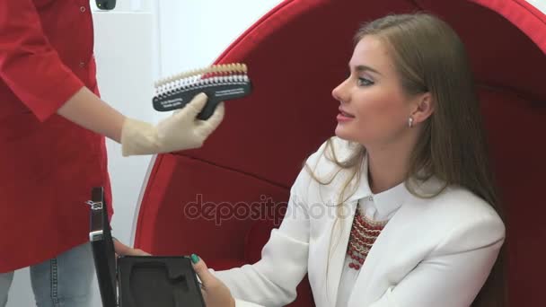 Jeune cliente regardant la variété de tons de dents — Video