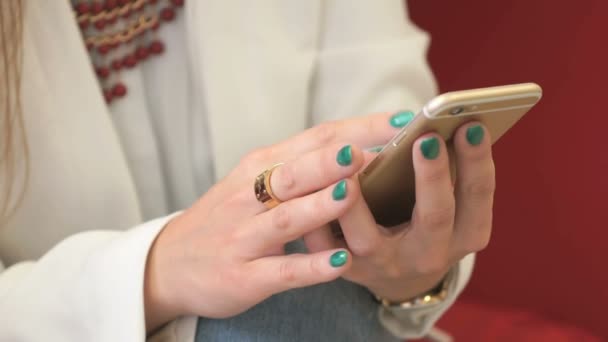 Жіночі руки використовують золотий смартфон. Крупним планом — стокове відео