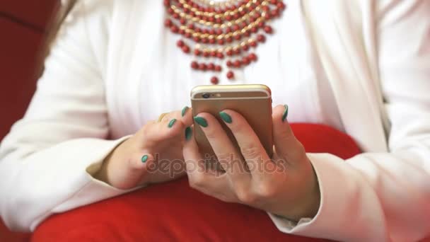 Женские руки используют золотой смартфон. Крупный план — стоковое видео