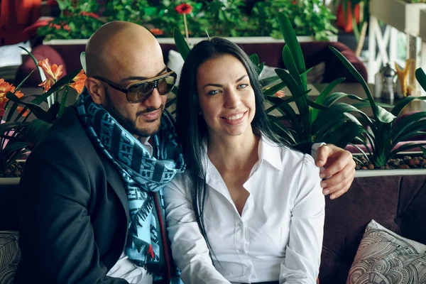 Arap adam oturuyor, güzel bir kız hugs