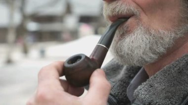 Yetişkin adam tütün boru kullanarak tütün sigara içiyor.