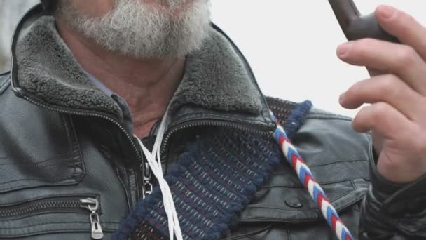 Взрослый мужчина с бородой курит с помощью табачной трубки — стоковое видео