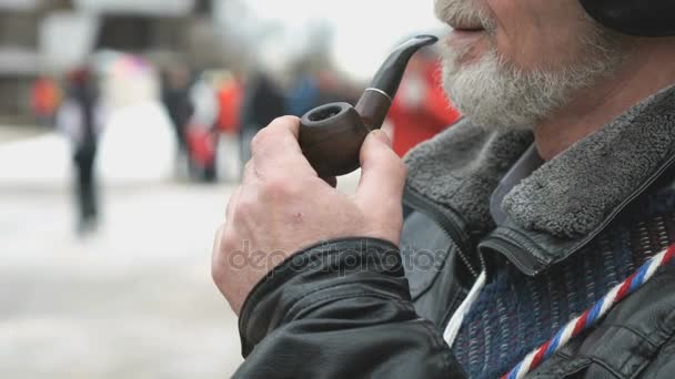 Взрослый мужчина с бородой курит с помощью табачной трубки — стоковое видео