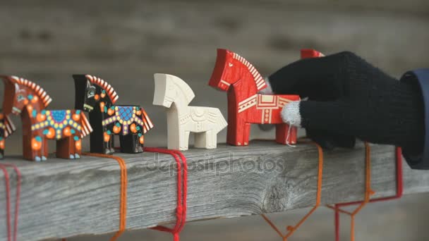 Рукою людини, вибравши один іграшки традиційних кінь — стокове відео