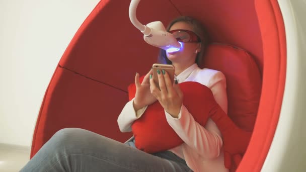 Klientin sitzt während der Zahnaufhellung im Stuhl — Stockvideo