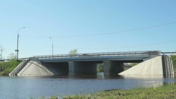Αυτοκίνητα που πηγαίνει στη γέφυρα πέρα από το μικρό ποτάμι ηλιόλουστη ημέρα — Αρχείο Βίντεο