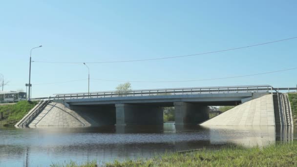 Cars going on bridge over small river on sunny day — Stock Video