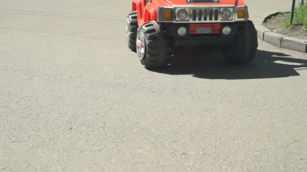 Дитина керує маленьким іграшковим автомобілем в парку атракціонів — стокове відео