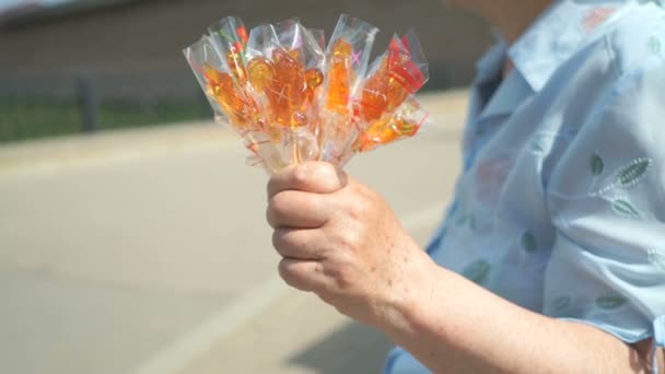 Senior adult woman selling homemade lollipops — Stock Video