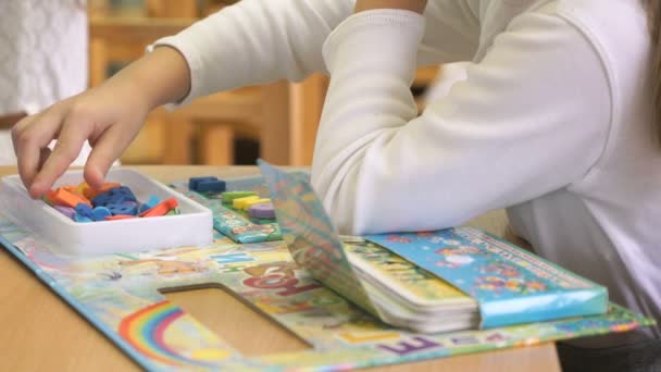 Händerna på barn lära sig bokstäverna under lektion — Stockvideo