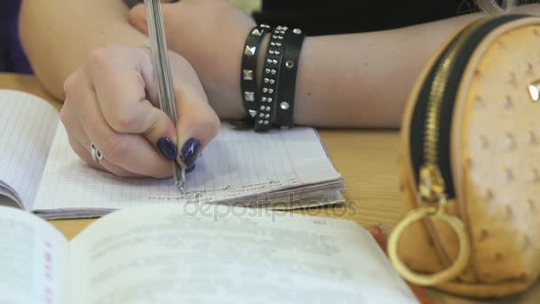 Uczeń zapisuje tekst w książce ćwiczenia, za pomocą pióra — Wideo stockowe