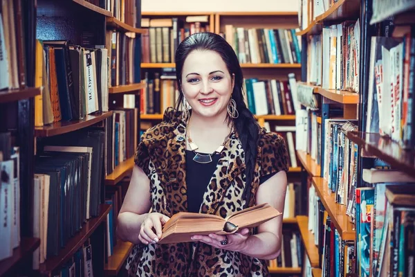 Kamera için poz gülümseyen kadın holding kitap