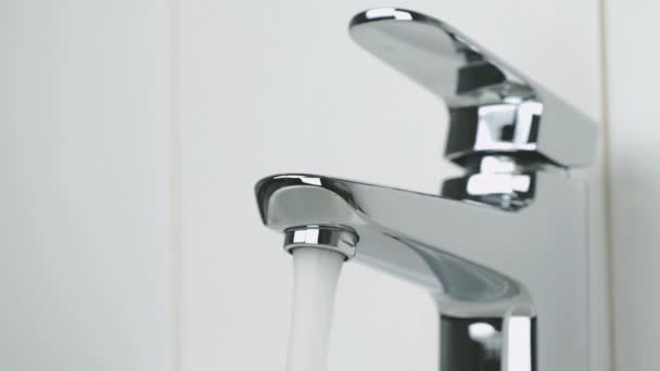 Flow of water is pouring from chrome-plated faucet — Stock Video