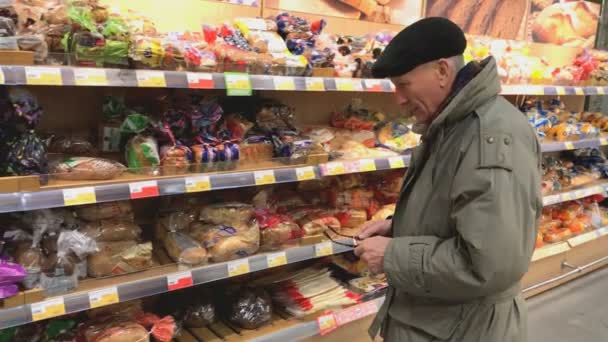 Дорослий людина вибирає loaf на Лента супермаркет — стокове відео
