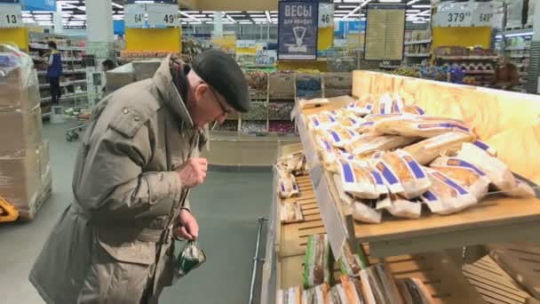 Взрослый человек выбирает буханку в супермаркете Лента — стоковое видео