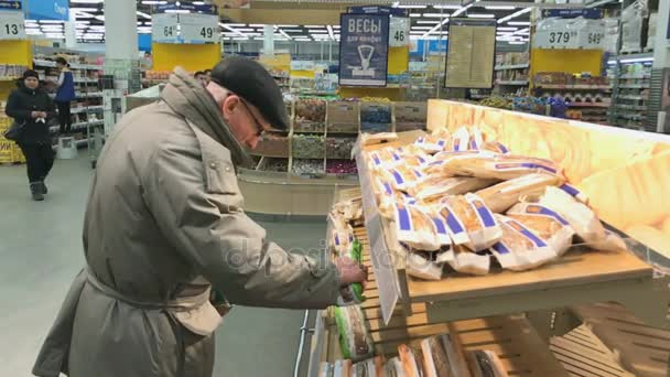 Älterer Mann wählt Brot im Lenta-Supermarkt — Stockvideo