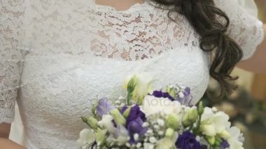 Gelin gelin buketi holding beyaz elbise giymiş