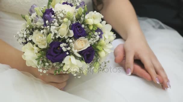 Bride and groom sitting on couch hold hands — Stock Video