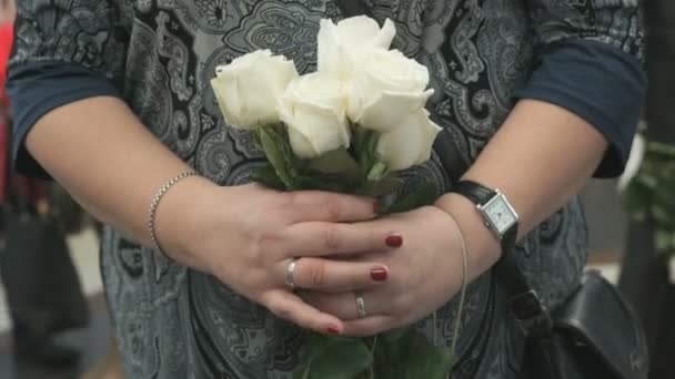 Donna sta in piedi e tiene bouquet di cinque rose bianche — Video Stock