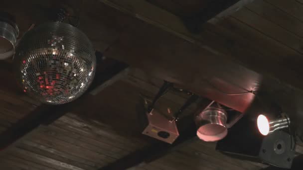 Rotating disco mirror ball in dark indoors — Stock Video