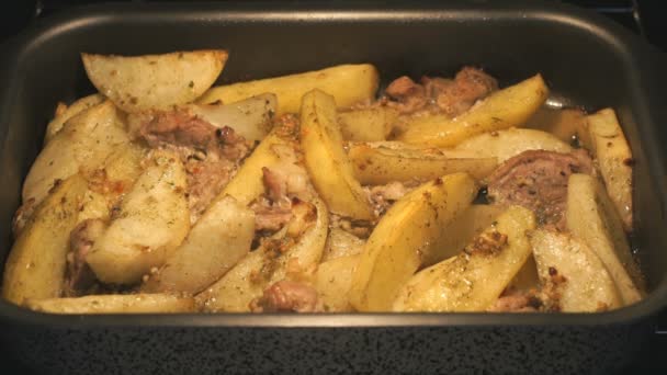 Gebakken aardappelen met varkensvlees in oven koken — Stockvideo